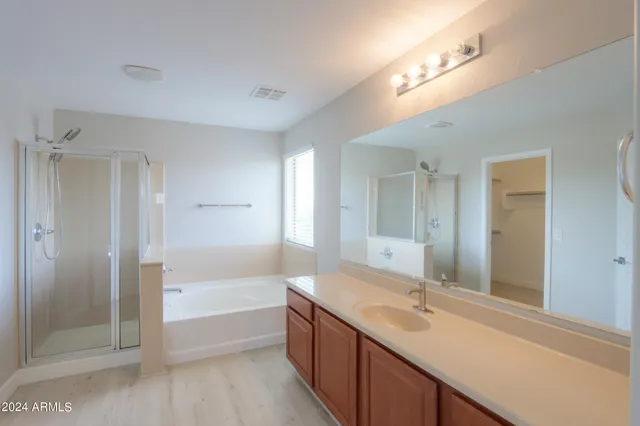 a bathroom with a sink double vanity granite tub shower and a mirror