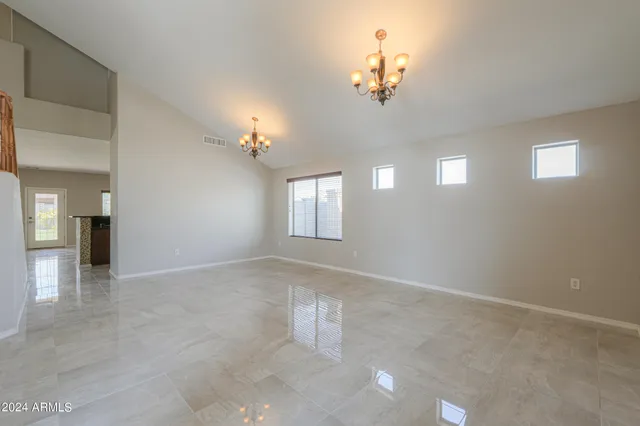 a view of an empty room with a chandelier fan