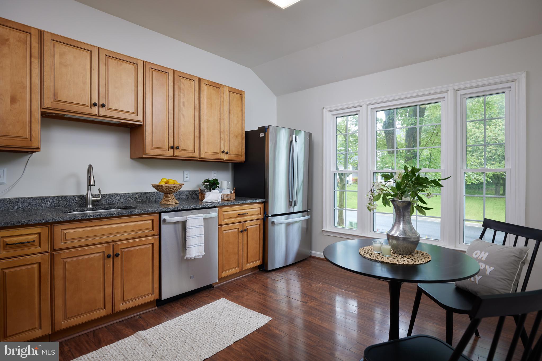 2723 Deer Ridge Drive Silver Spring, MD 20904 - Photo 12 of 45 a kitchen with stainless steel appliances granite countertop a stove a refrigerator a sink a dining table and chairs with wooden floor