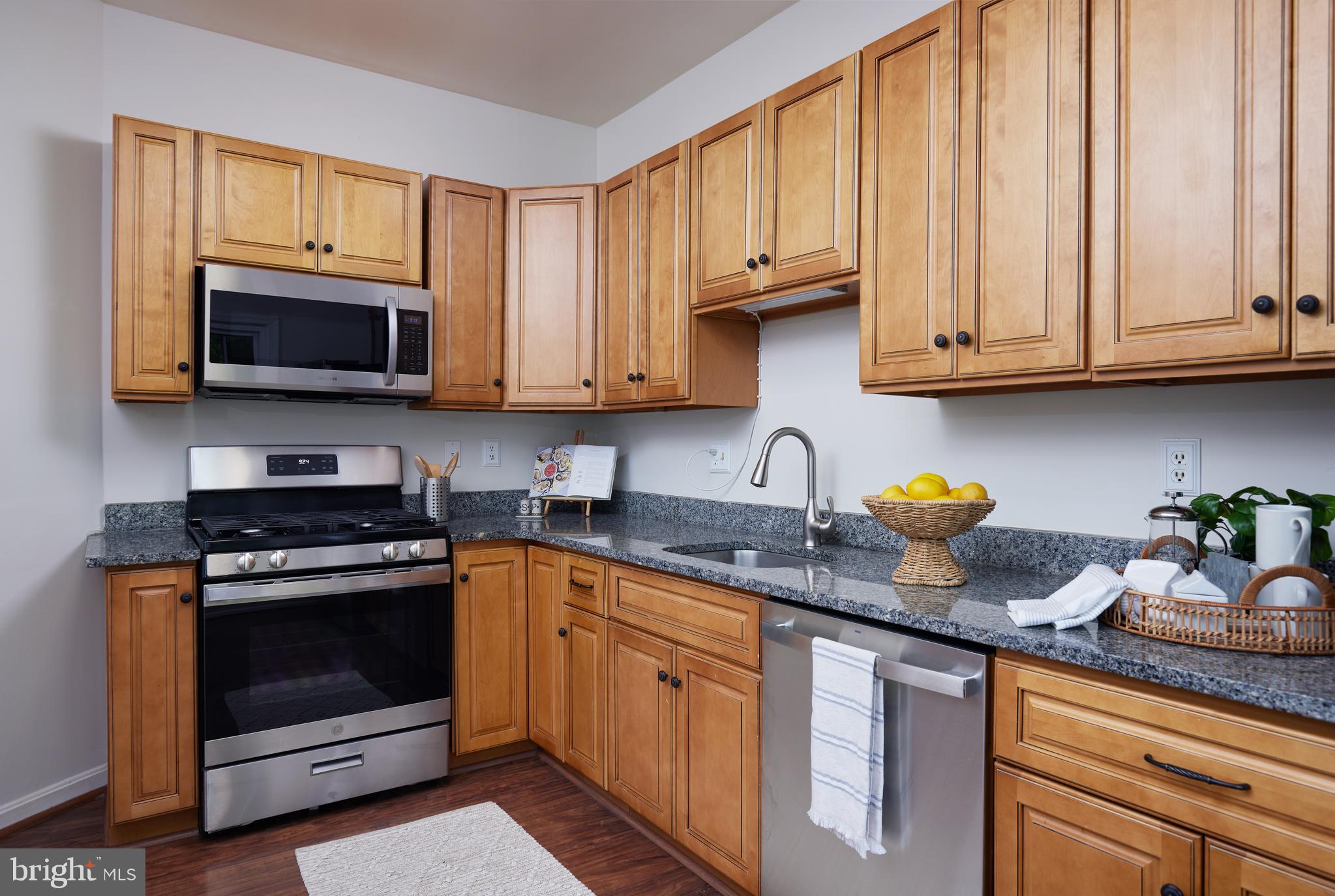 2723 Deer Ridge Drive Silver Spring, MD 20904 - Photo 13 of 45 a kitchen with granite countertop a stove top oven microwave and cabinets