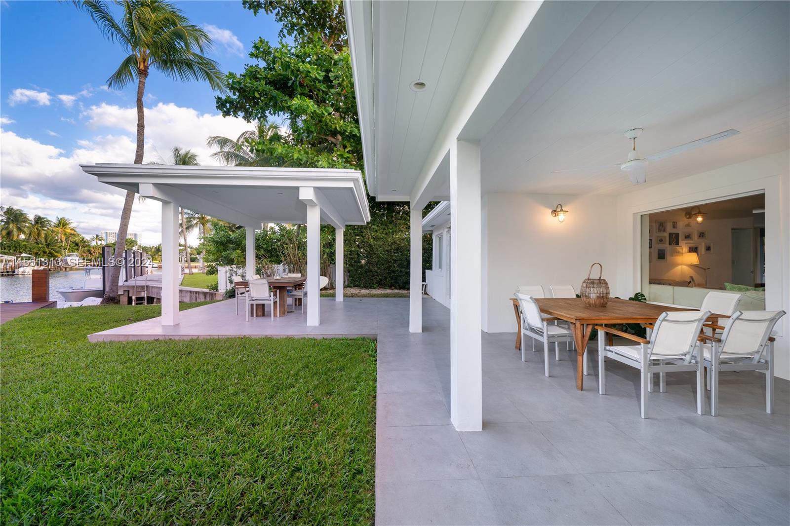 861 Harbor Drive Key Biscayne, FL 33149 - Photo 14 of 33 a view of a patio with table and chairs potted plants and palm trees