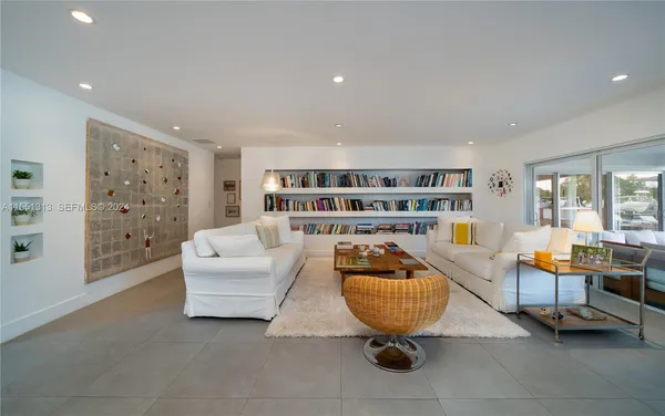 a living room with furniture a rug and white walls