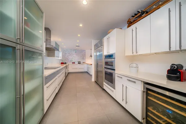a kitchen with stainless steel appliances a refrigerator sink and cabinets