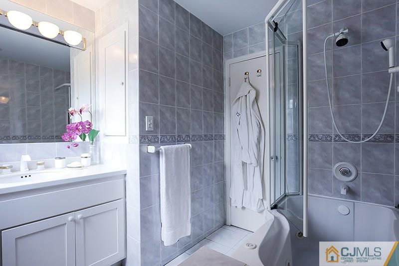29 Nottingham Road Edison, NJ 08820 - Photo 13 of 18 a bathroom with a double vanity sink a mirror and shower