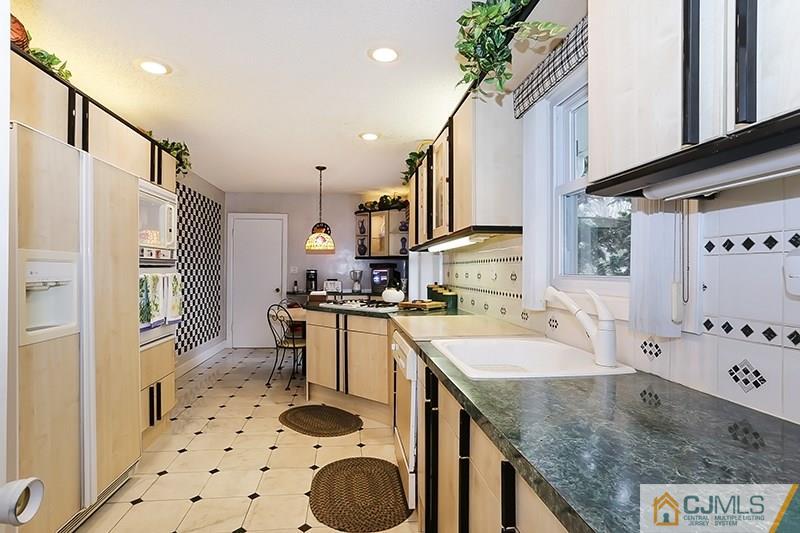 29 Nottingham Road Edison, NJ 08820 - Photo 3 of 18 a kitchen with granite countertop a sink a stove a refrigerator and cabinets