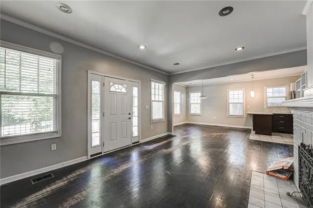 a kitchen with kitchen island a stove a refrigerator a sink dishwasher with a dining table and chairs with wooden floor