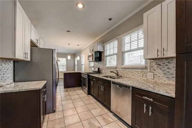 a kitchen with stainless steel appliances granite countertop a sink stove and microwave