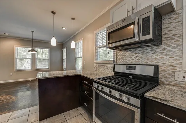 a kitchen with stainless steel appliances granite countertop a stove a refrigerator and a sink
