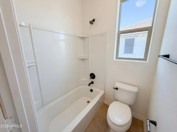 a white toilet sitting next to a bath tub