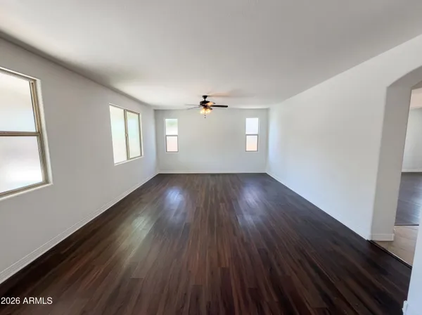 an empty room with wooden floor and windows