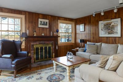 228 Huckins Neck Road Centerville, MA 02601 - Photo 13 of 19 a living room with furniture a large window and a fireplace