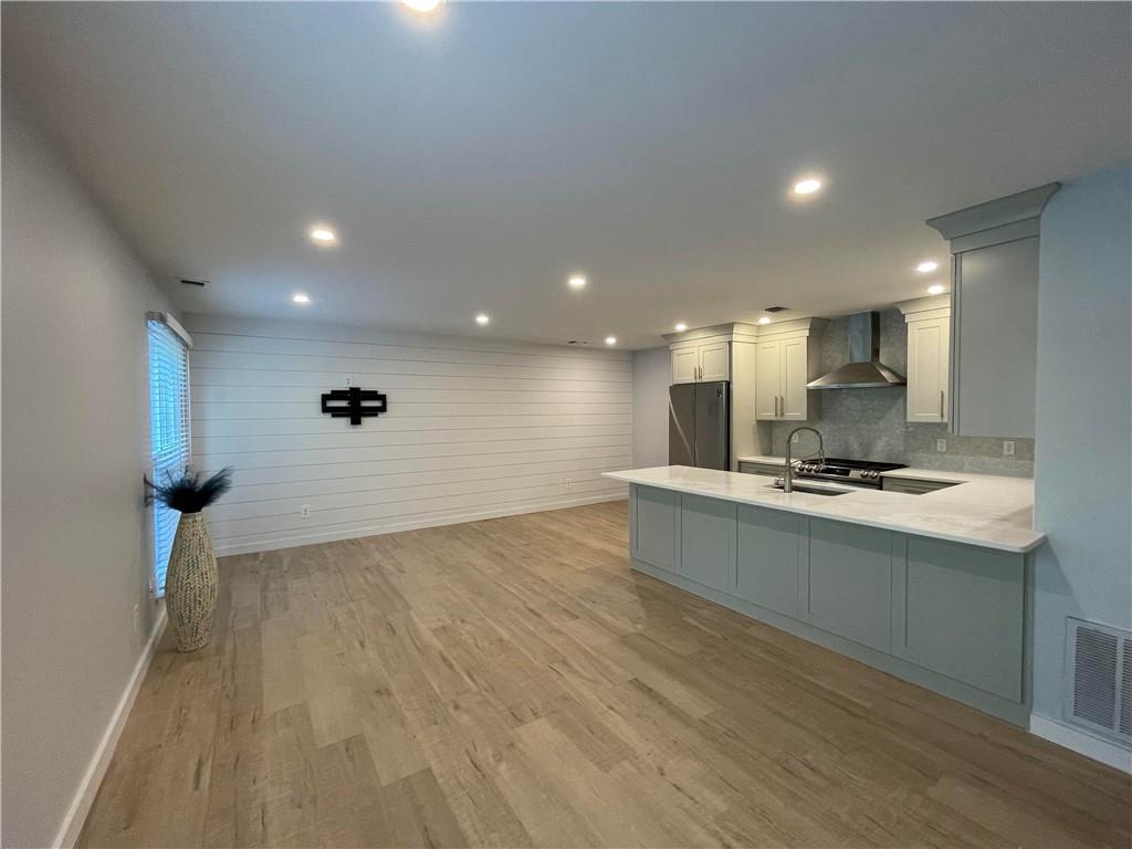 19 The Rise Warwick, NY 10990 - Photo 1 of 1 Kitchen with white cabinetry, stainless steel refrigerator, light hardwood / wood-style flooring, and wall chimney exhaust hood