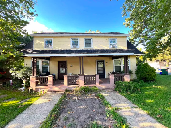 a front view of a house with garden and porch