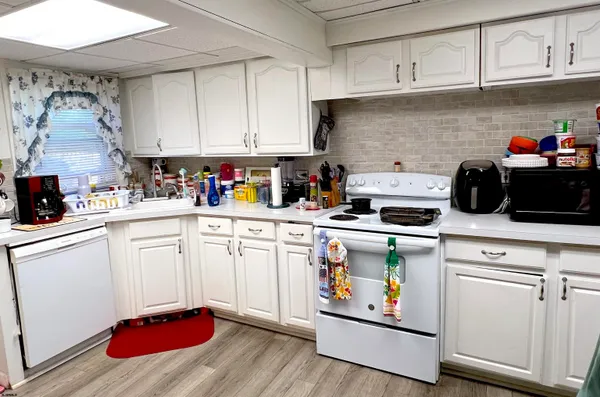 a kitchen with white cabinets and white appliances