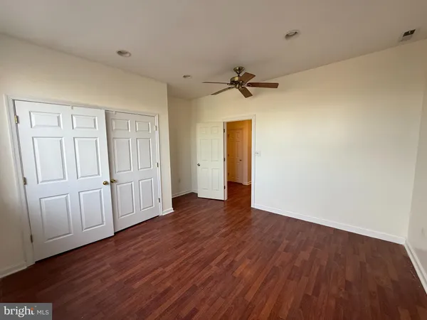 a view of a livingroom with wooden floor and a ceiling fan
