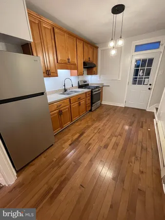 a kitchen with stainless steel appliances a refrigerator a sink dishwasher a stove with wooden floor