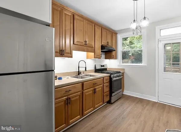a kitchen with stainless steel appliances granite countertop a refrigerator a sink dishwasher a stove with wooden cabinets and a window