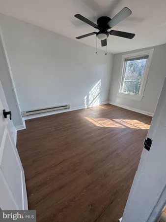 a view of an empty room with a window and a ceiling fan