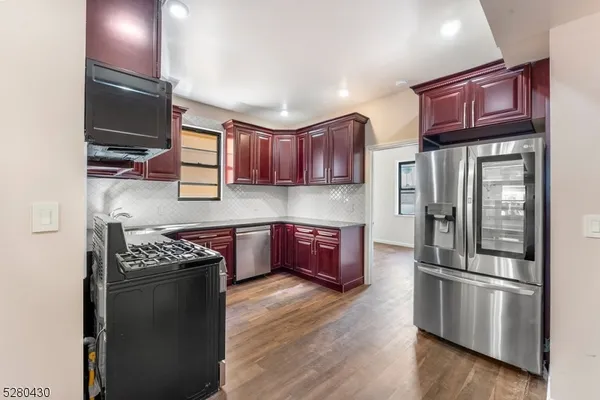 a kitchen with stainless steel appliances granite countertop a refrigerator stove and sink