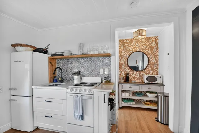 a kitchen with stainless steel appliances granite countertop a stove and a wooden floors