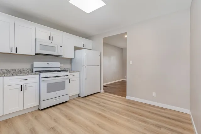 a kitchen with white cabinets and white appliances