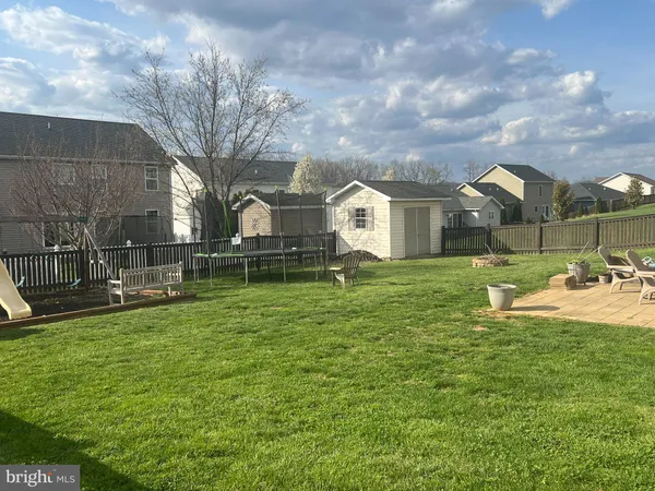 a view of a house with a big yard and a large tree