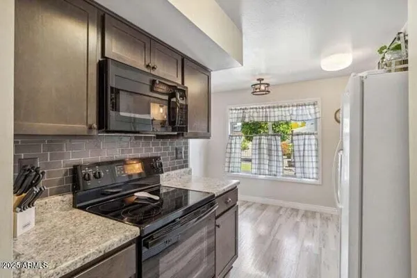 a kitchen with stainless steel appliances granite countertop a stove a sink and a microwave