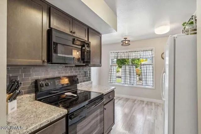 a kitchen with stainless steel appliances granite countertop a stove a sink and a microwave