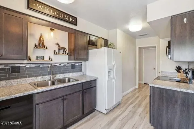 a kitchen with a sink a refrigerator and cabinets