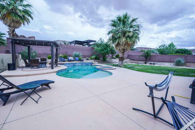 3683 South 2640 West St. George, UT 84790 - Photo 40 of 41 Curved swimming pool with an integrated spa, surrounded by expansive concrete decking