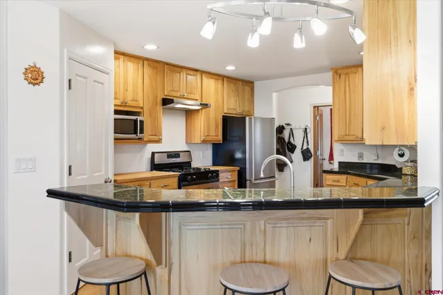 a kitchen with stainless steel appliances granite countertop a sink stove and refrigerator
