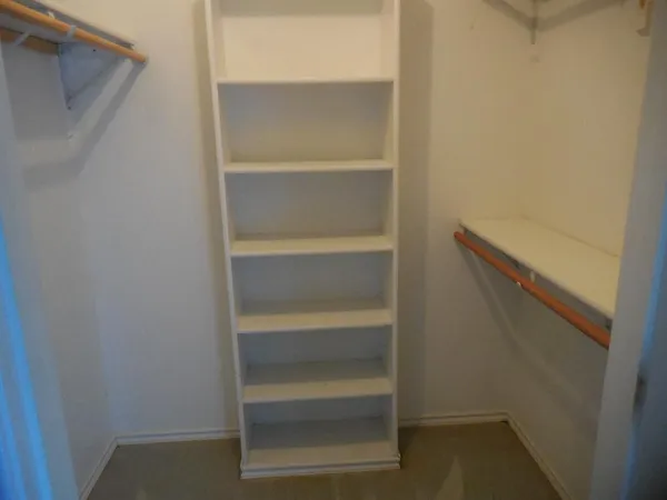 a view of walk in closet with empty racks