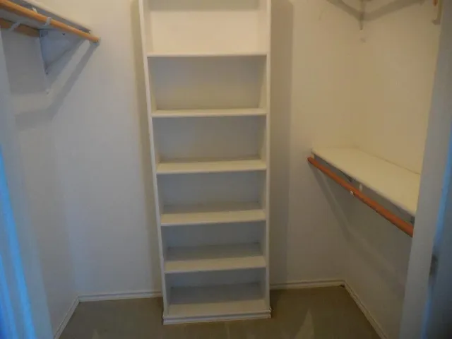 a view of walk in closet with empty racks