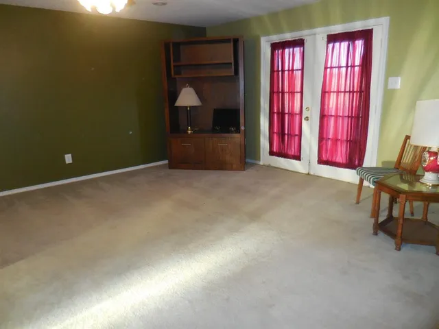 an empty room with windows furniture and a fireplace