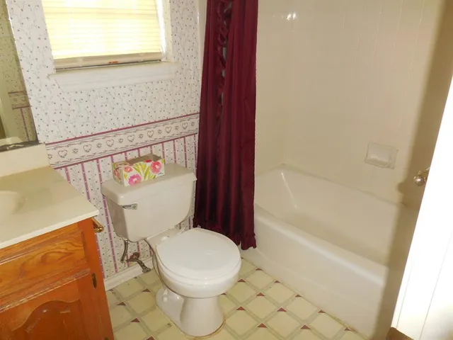 a white toilet sitting next to a bath tub