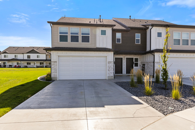 3097 Old Emigrant Road, Unit A Syracuse, UT 84075 - Photo 1 of 27 Contemporary townhome featuring a two-car garage, concrete driveway, and stone accents