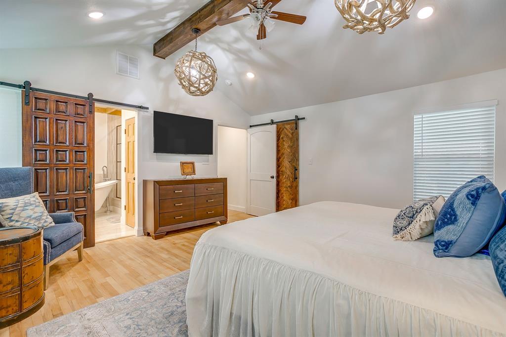 508 South Elm Street Weatherford, TX 76086 - Photo 20 of 40 a bedroom with a bed and a flat tv screen on dresser