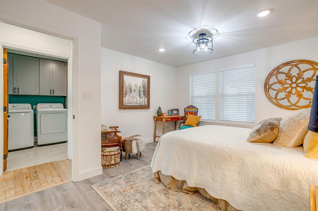 508 South Elm Street Weatherford, TX 76086 - Photo 28 of 40 a bedroom with a bed and a chandelier