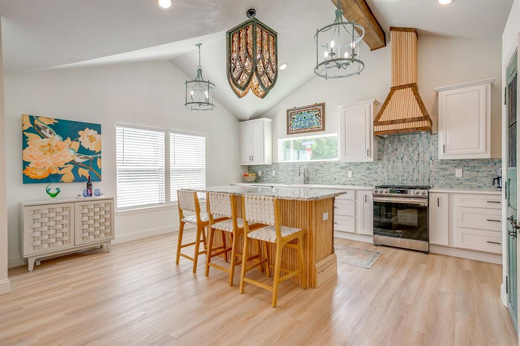 508 South Elm Street Weatherford, TX 76086 - Photo 6 of 40 a dining room with wooden floor a chandelier a wooden table and chairs