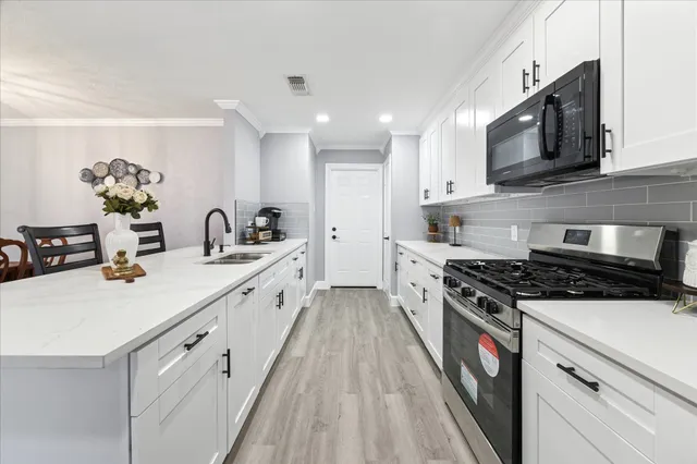 a kitchen with stainless steel appliances a sink dishwasher stove microwave and cabinets