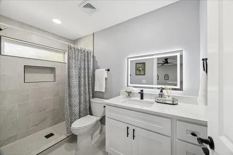 a bathroom with a sink a toilet and shower