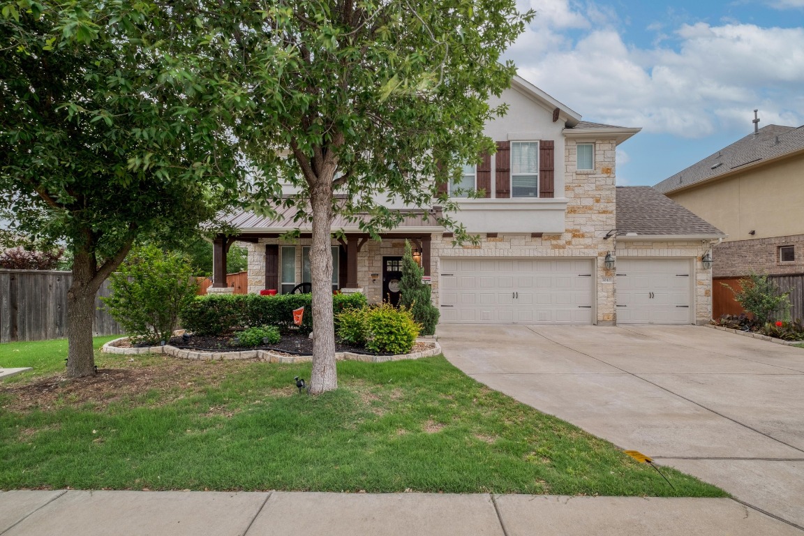a front view of a house with a yard and trees