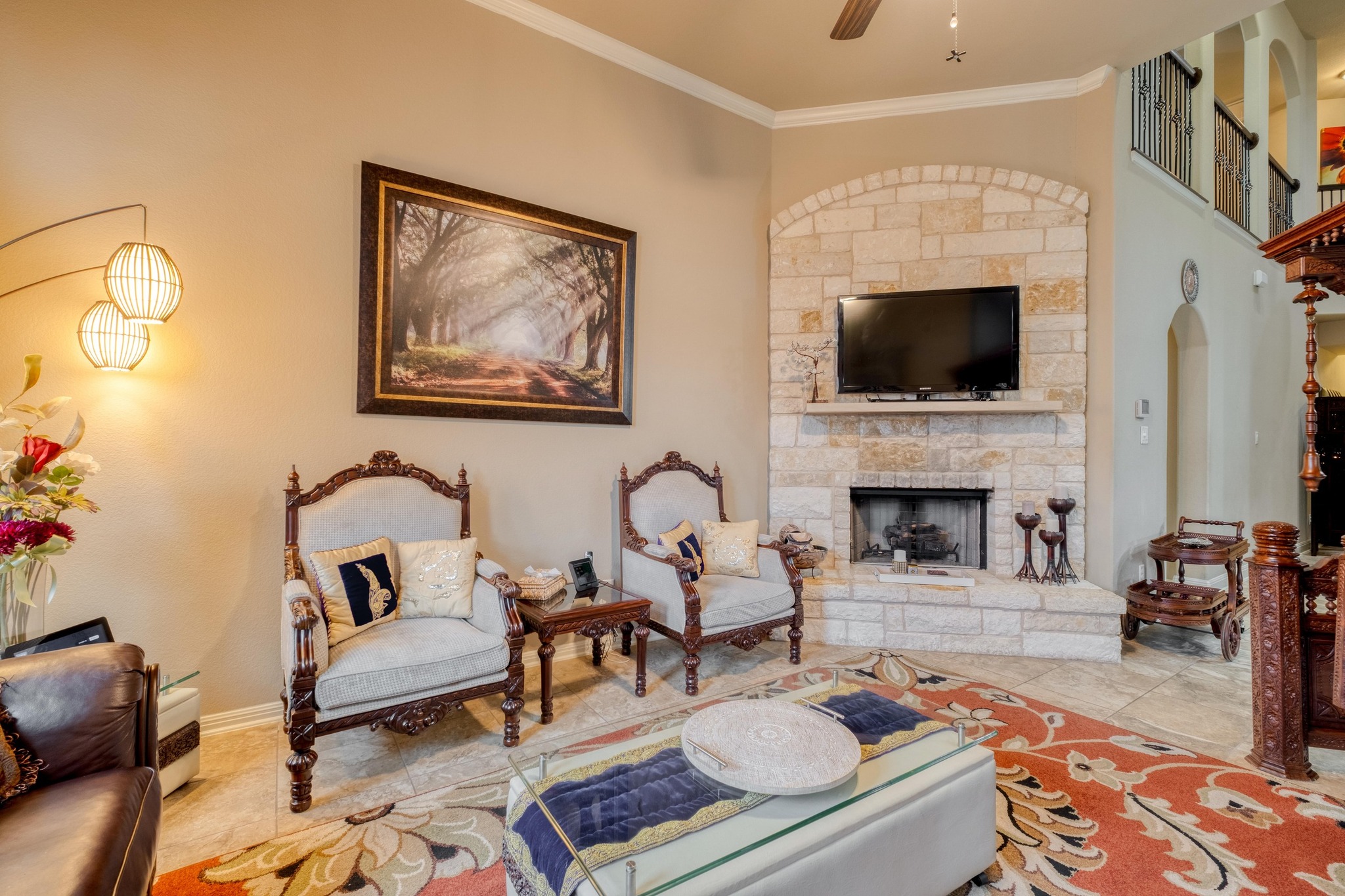3040 Sachen Street Georgetown, TX 78626 - Photo 7 of 40 Living area featuring arched walkways, ornamental molding, a fireplace, ceiling fan, and tile patterned flooring
