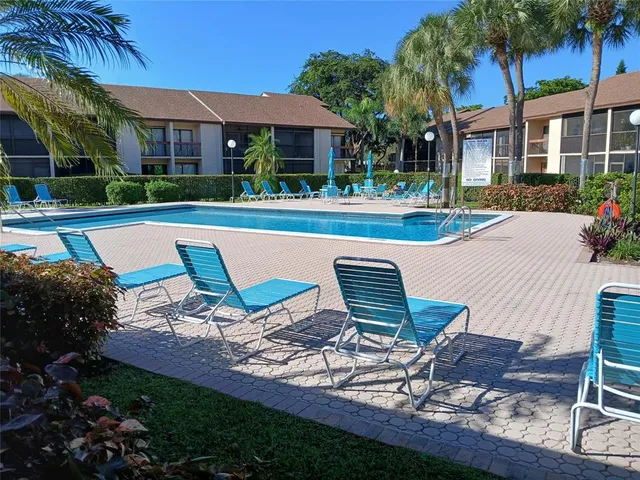 a view of a house with pool and chairs