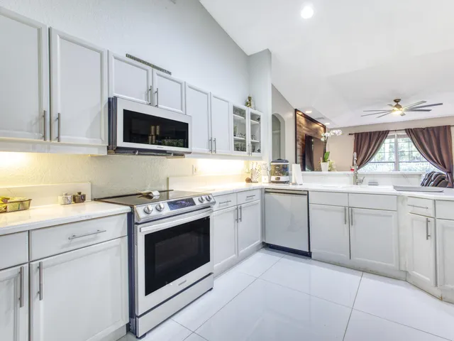 a kitchen with white cabinets appliances and a sink