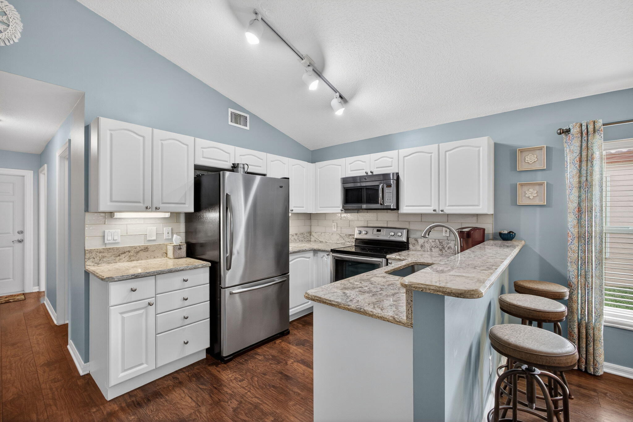 1095 Via Jardin Riviera Beach, FL 33418 - Photo 8 of 44 a kitchen with stainless steel appliances kitchen island granite countertop a refrigerator stove microwave and sink
