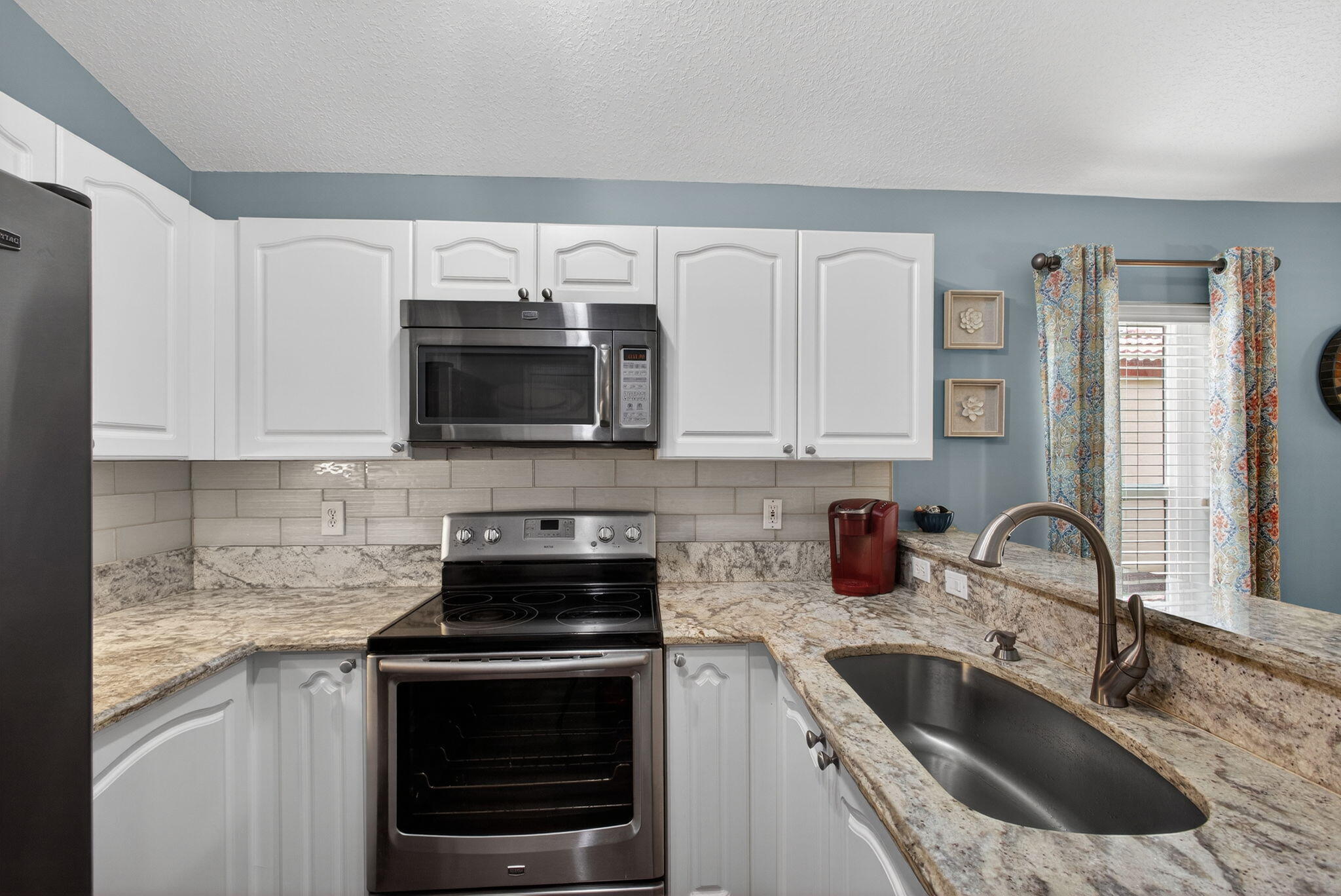 1095 Via Jardin Riviera Beach, FL 33418 - Photo 9 of 44 a kitchen with granite countertop a sink and a stove top oven