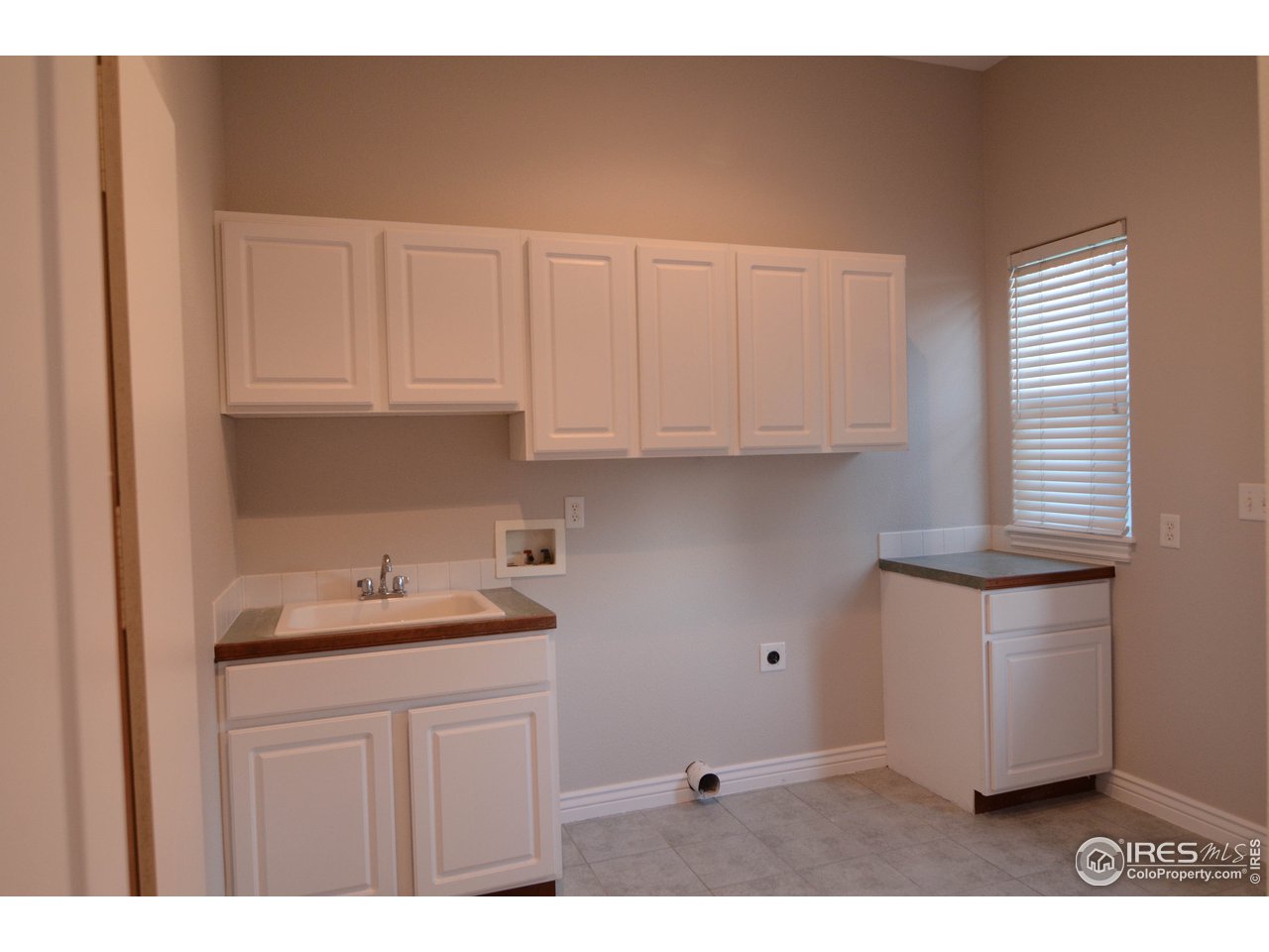 1797 Ridge W Drive Windsor, CO 80550 - Photo 12 of 33 a kitchen with granite countertop white cabinets and sink