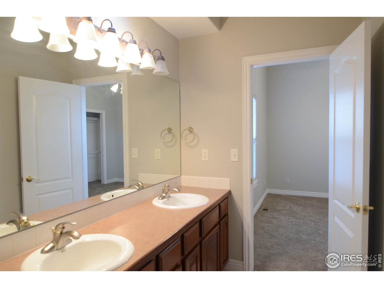 1797 Ridge W Drive Windsor, CO 80550 - Photo 18 of 33 a bathroom with a double vanity sink and a mirror