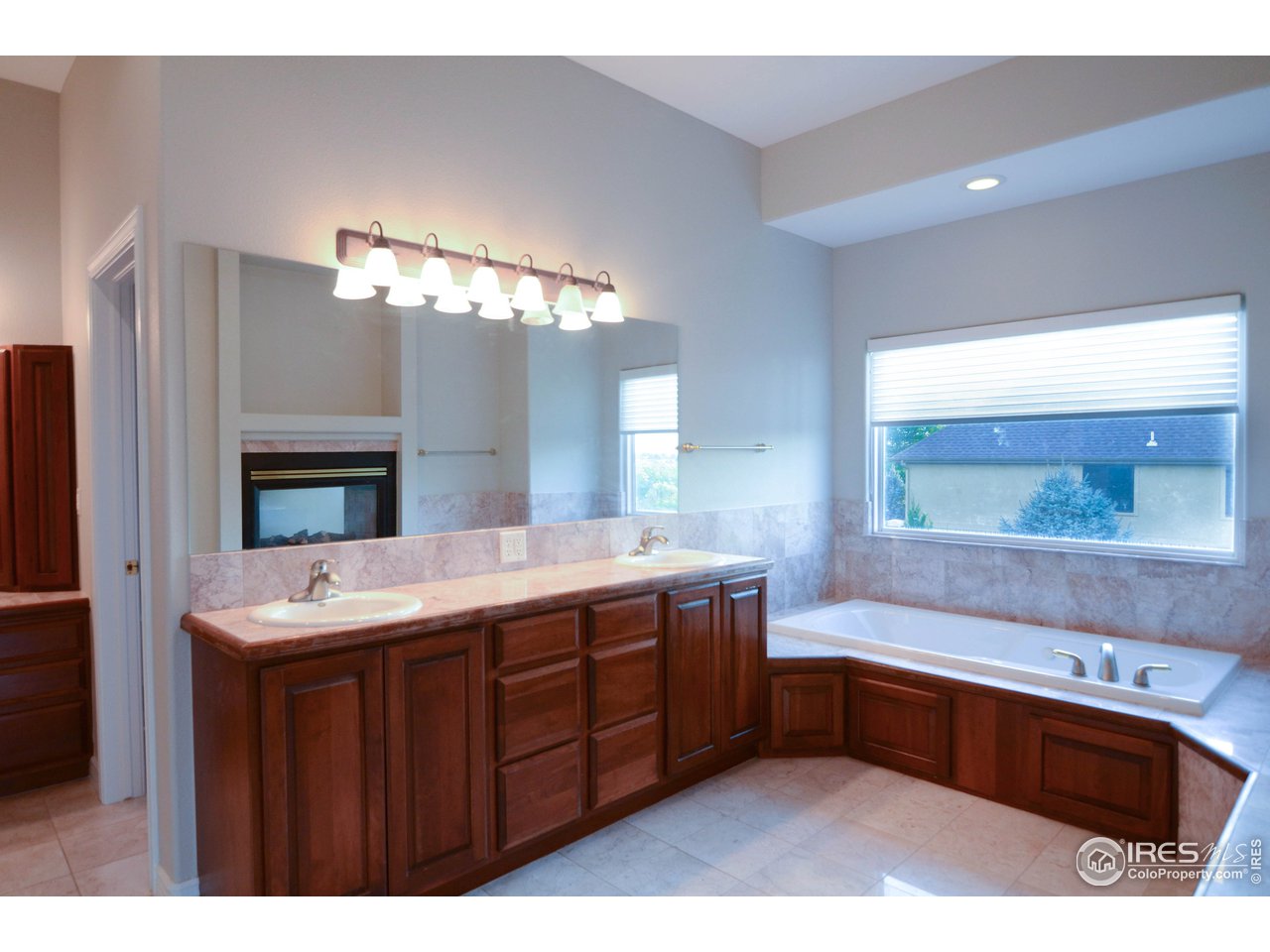1797 Ridge W Drive Windsor, CO 80550 - Photo 23 of 33 a spacious bathroom with a bathtub a double vanity sink a vanity and a large mirror